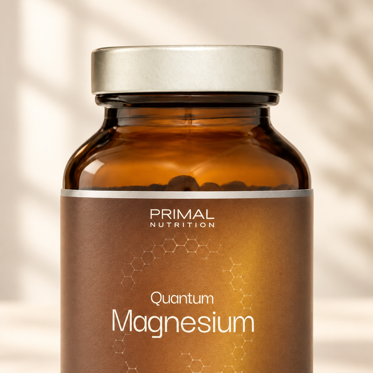 Detail lahvičky Quantum Magnesium – stříbrné víčko, hnědé sklo a etiketa Primal Nutrition